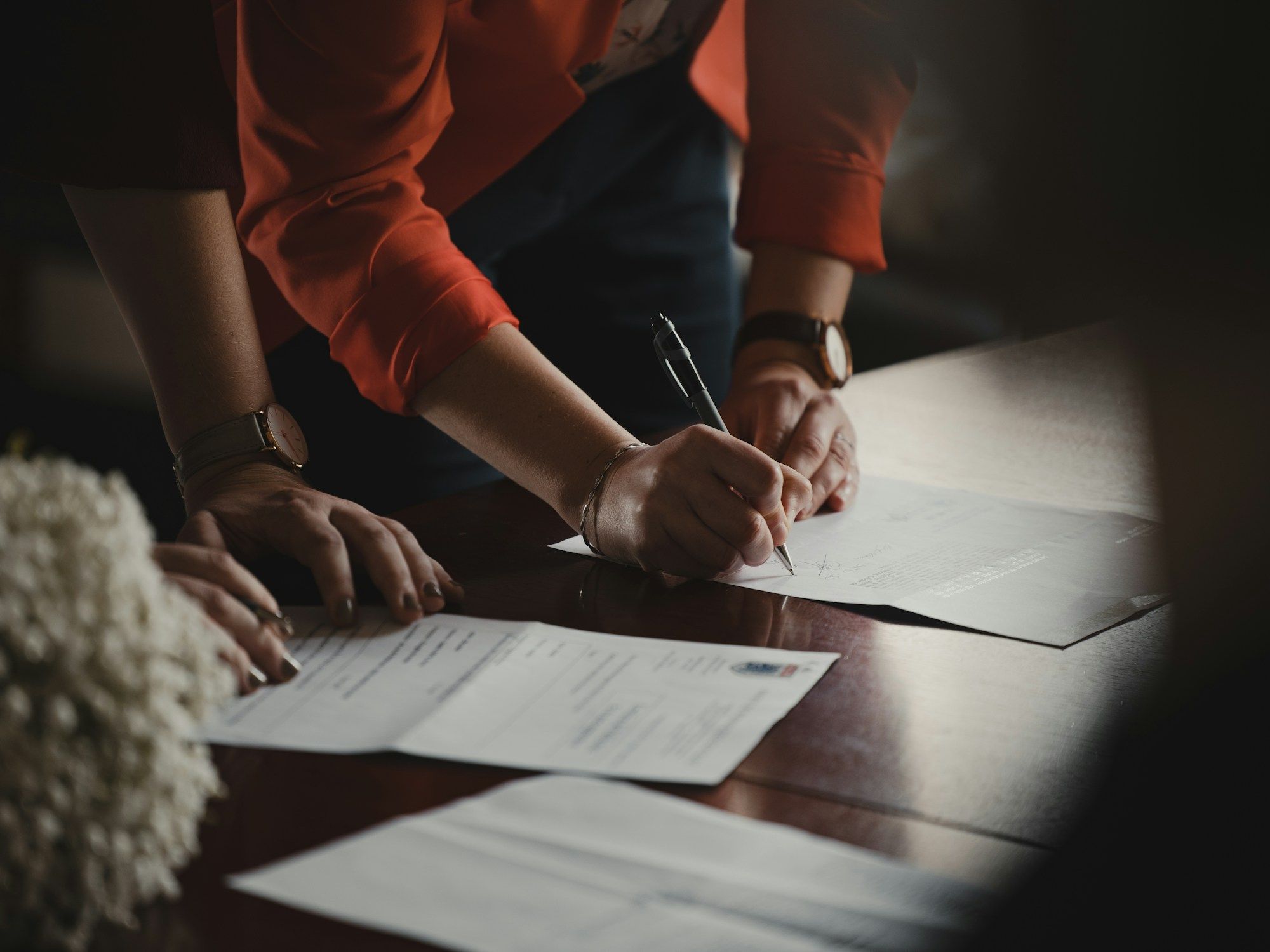 Two people signing a contract at a table